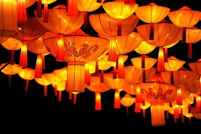 Low angle view of illuminated lanterns hanging at night