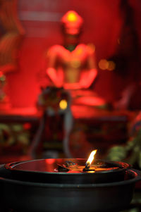 Close-up of lit tea light candle in temple