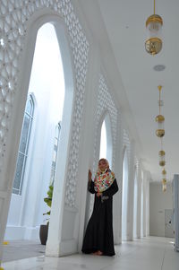 Full length of teenage girl wearing traditional clothing standing in corridor