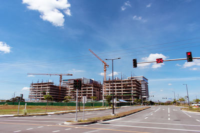 View of city street against cloudy sky