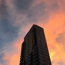 Low angle view of buildings against cloudy sky