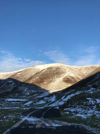 Scenic view of sand dunes against sky