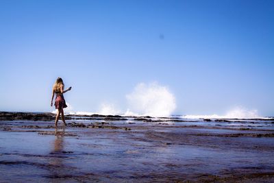 Scenic view of sea waves against clear blue sky