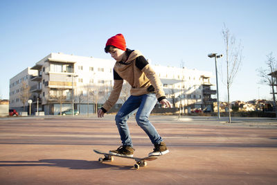 Male skateboarder riding and practicing skateboard in city outdoors
