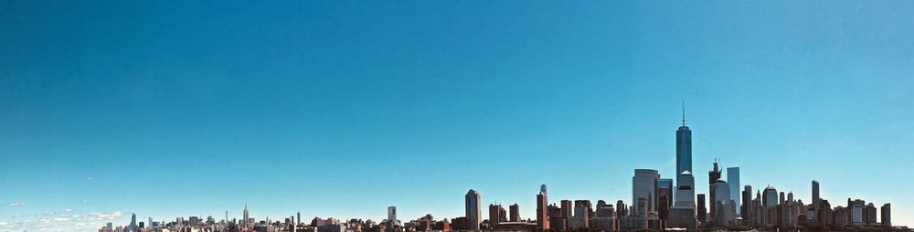 Buildings in city against blue sky