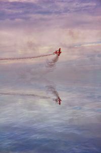 Airplane flying over sea against sky