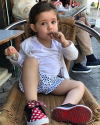 Portrait of cute girl sitting outdoors