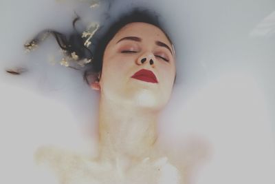 Close-up of woman lying in bathtub