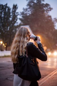 Woman wearing sunglasses standing against sky