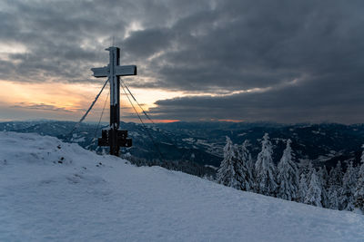 Scenic view of snowcapped field against sky during sunset