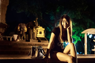 Portrait of a young woman sitting on table