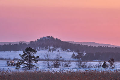 Scenic view of snow covered landscape against sky during sunset