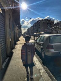 Rear view of man with umbrella in city