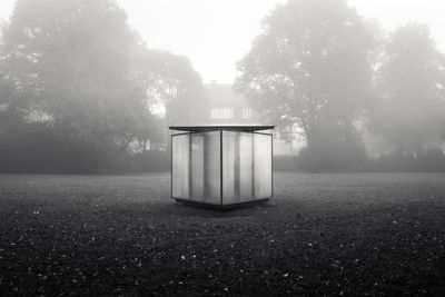 Lifeguard hut on field in foggy weather