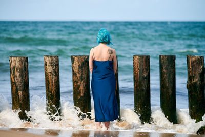 Rear view of woman looking at sea against sky