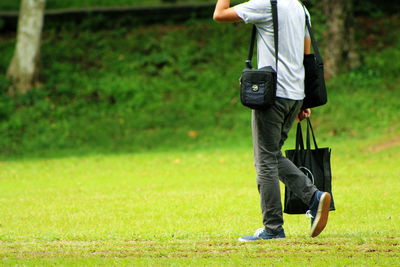 Low section of man walking on field