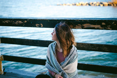 Young woman standing on pier against sea