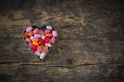 Close-up of colorful candies in heart shape pastry cutter on table