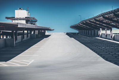 Empty parking lot against clear sky on sunny day