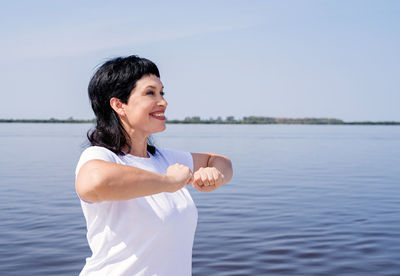 Smiling woman standing by lake