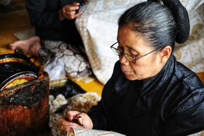 Close-up of mature woman working in factory