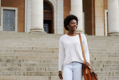 Woman looking away while standing outdoors