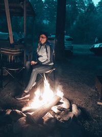 Young man sitting on log