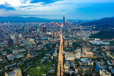 High angle view of city buildings against cloudy sky