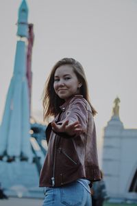 Portrait of beautiful woman standing against sky