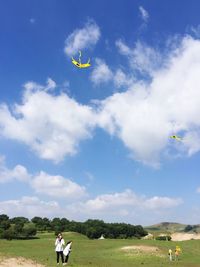 Woman flying kite against sky