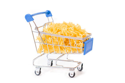 Close-up of miniature shopping cart against white background