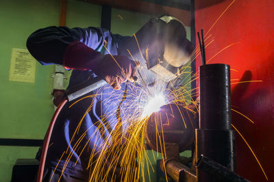 Welder working in auto repair shop