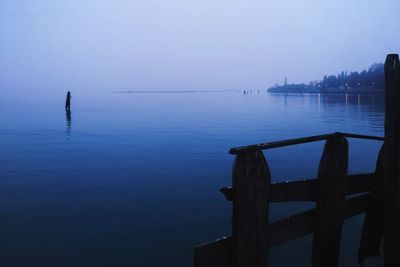 Silhouette pier on sea against sky at dusk