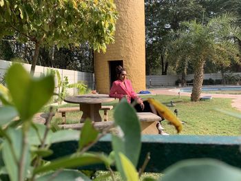 Woman sitting on seat in yard