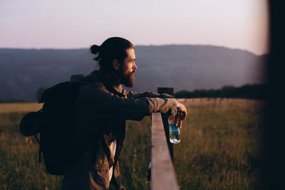 Full length of man photographing while standing on field