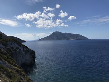 Scenic view of sea and mountains against sky