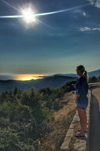 Woman standing on mountain against sky