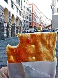 Close-up of ice cream cone on street in city