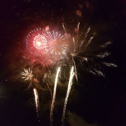 Low angle view of firework display at night