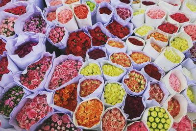 Full frame shot of colorful flowers arranged in paper bags at market for sale