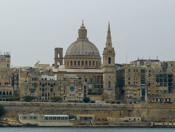 Buildings in city against clear sky