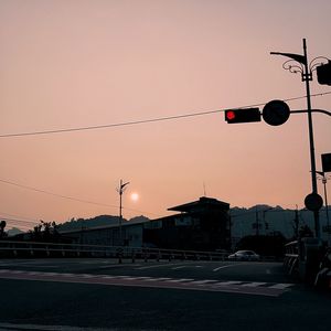 Street lights against sky during sunset