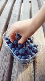 Cropped image of man holding blueberries