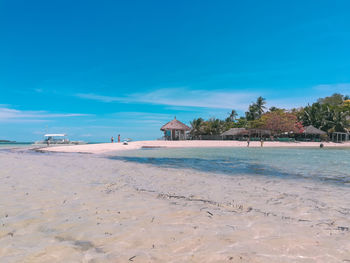 Scenic view of beach against blue sky