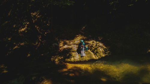Woman walking on rock in forest