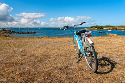 One bicycle parked against the sea in the island of batz with no people. summer adventure