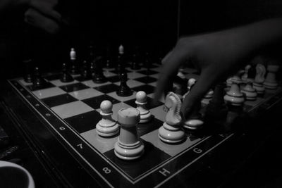 Cropped hand playing chess in darkroom