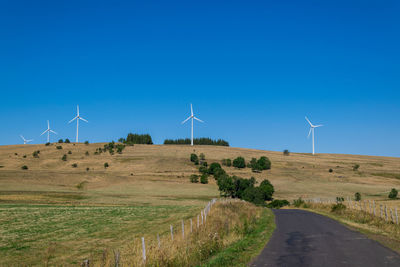 Windmills on field against sky