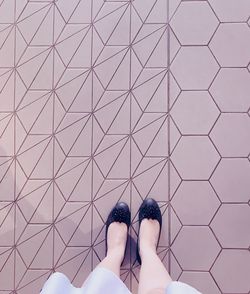 Low section of woman standing on footpath