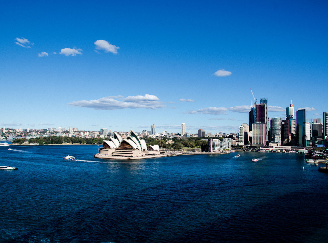 building exterior, built structure, architecture, city, sky, water, office building exterior, waterfront, nautical vessel, building, transportation, travel, travel destinations, skyscraper, no people, blue, day, cityscape, nature, modern, outdoors, cruise ship, passenger craft, yacht, financial district